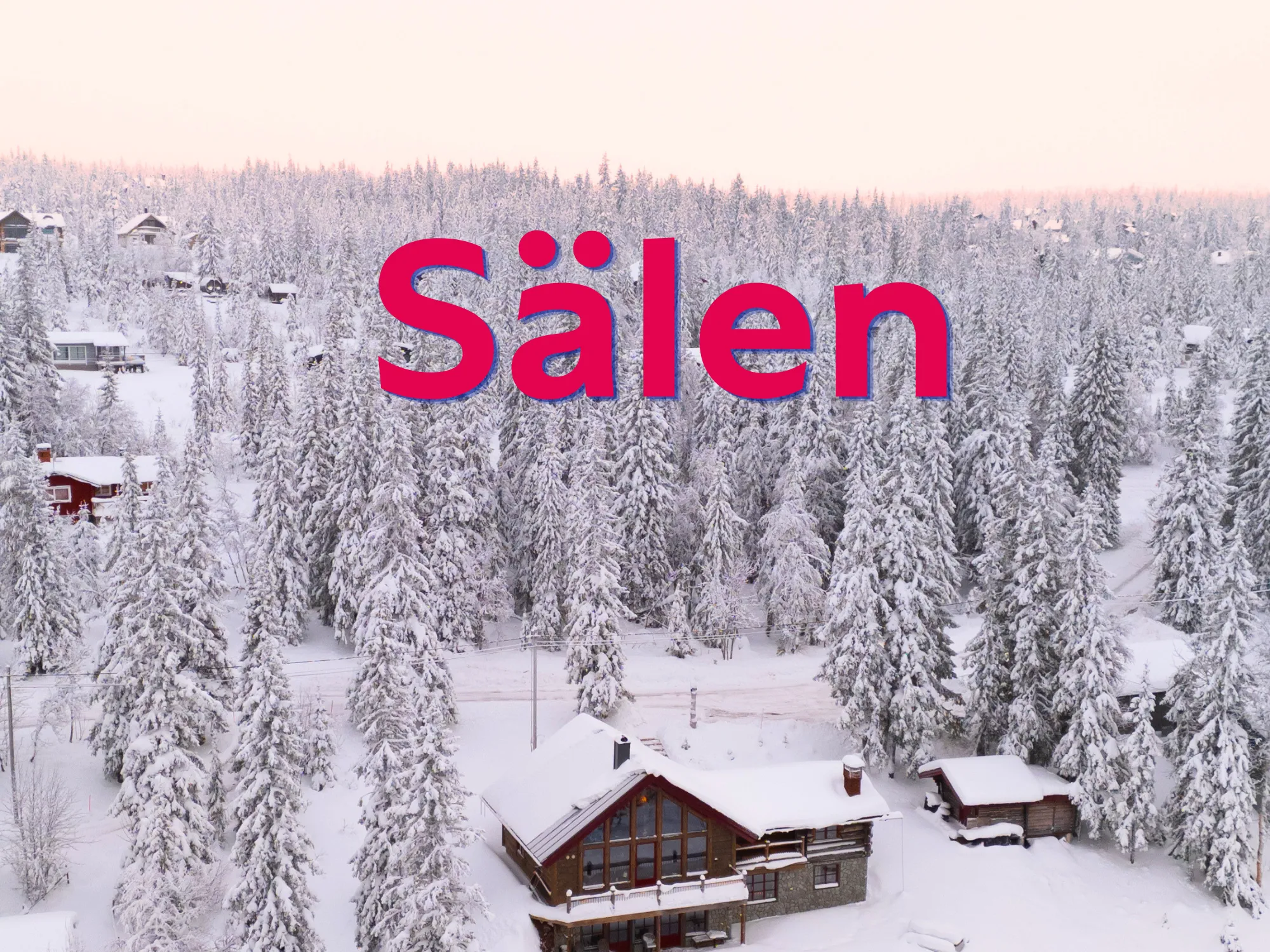 Vinterlandskab med hyggelige hytter og sneklædte skibakker i baggrunden.